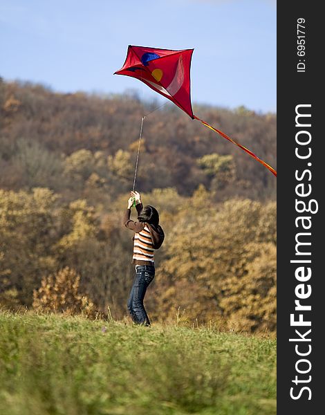 Fly a kite, teenager in fall weather in nature