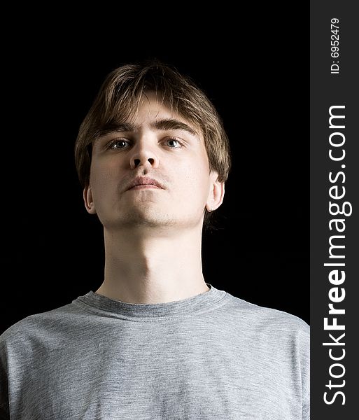 Close up portrait of young man on black background