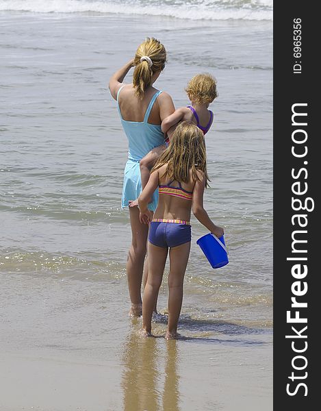 Mother and daughters  playing in  the waves. Mother and daughters  playing in  the waves