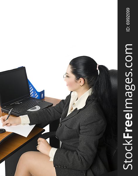 Business woman write on a paper and look at laptop,more photos with this model in Business people ,laptop and money. Business woman write on a paper and look at laptop,more photos with this model in Business people ,laptop and money