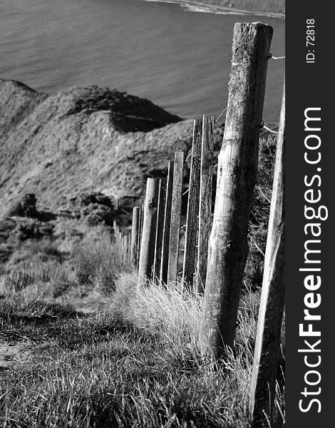 A long fence line leading down to the ocean from the Makara Hill gun emplacements, Wellington, New Zealand. A long fence line leading down to the ocean from the Makara Hill gun emplacements, Wellington, New Zealand