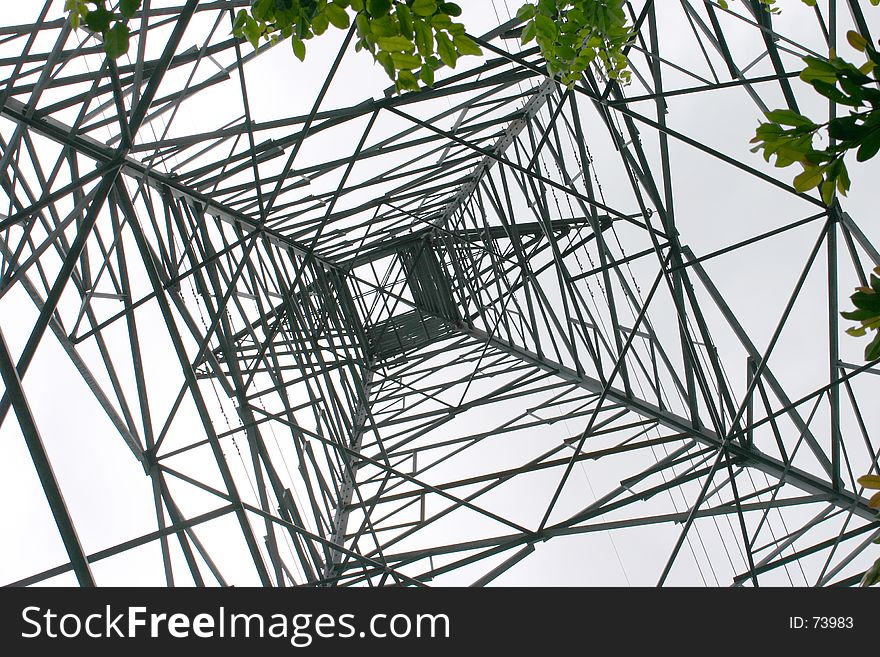 Looking up through the web of steel of a high voltage electricity tower. Looking up through the web of steel of a high voltage electricity tower