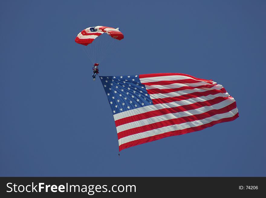 A skydiver coming down to earth with the American flag. A skydiver coming down to earth with the American flag.