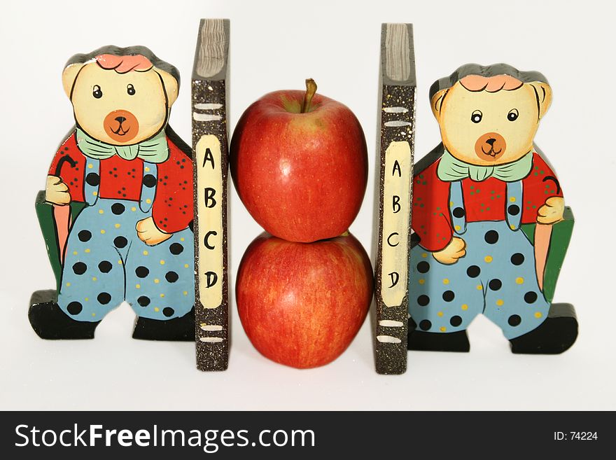 Two apples in the middle of two book holders. Two apples in the middle of two book holders