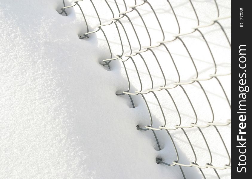 Snow and chain-link fence. Snow and chain-link fence.