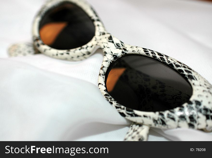 Glasses with dark lenses and snake skin print frame. Glasses with dark lenses and snake skin print frame.