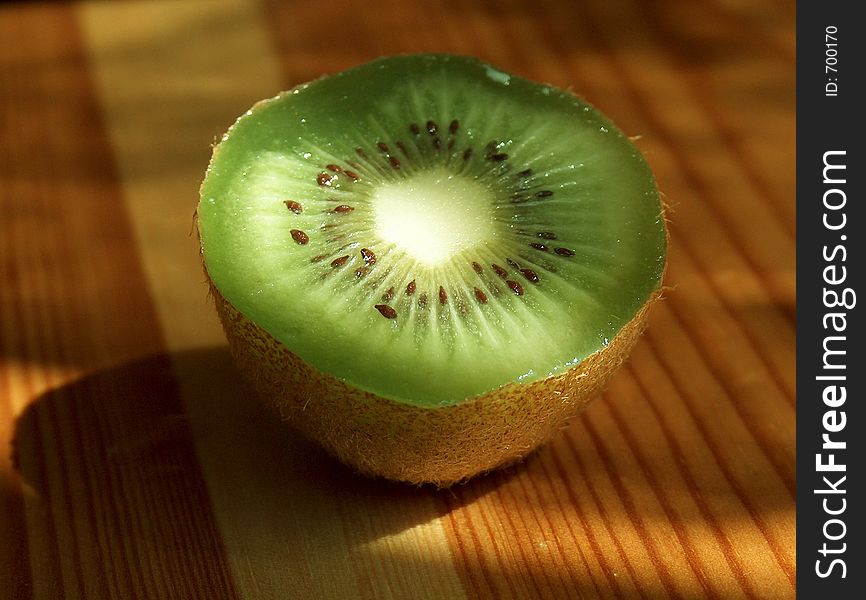 Fresh kiwi cut on half on wooden table