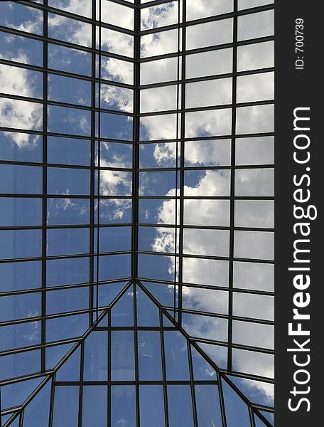 Blue sky with clouds viewed through glass roof of an atrium