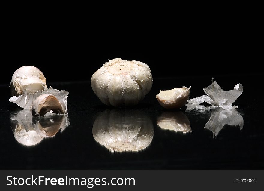 White garlic with drop water on bleck background