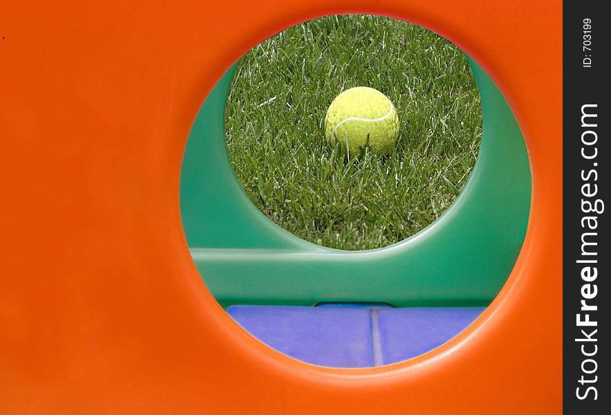 Yellow ball framed by circular holes of a child's play structure. Yellow ball framed by circular holes of a child's play structure.