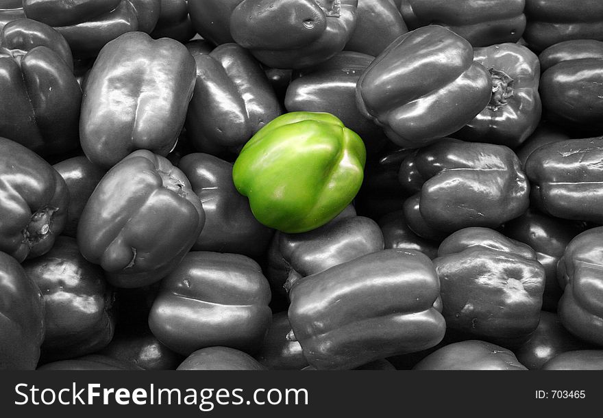 Isolated green bell pepper in the middle of many green bell peppers. Isolated green bell pepper in the middle of many green bell peppers