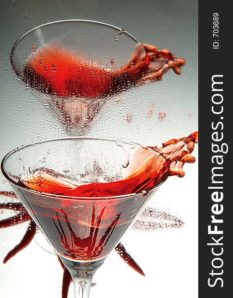 Red wine splattering from two wine glasses. Red wine splattering from two wine glasses