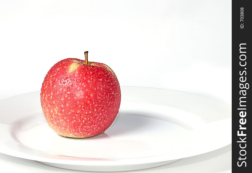 Red apple on a white plate