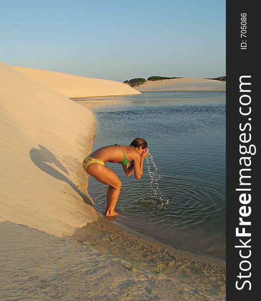 Girl washing the face in the lagoon. Girl washing the face in the lagoon.