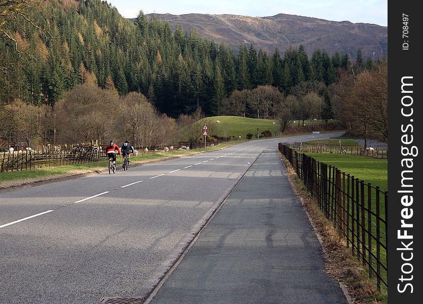Two cyclists on a road in scenic North Wales. Two cyclists on a road in scenic North Wales