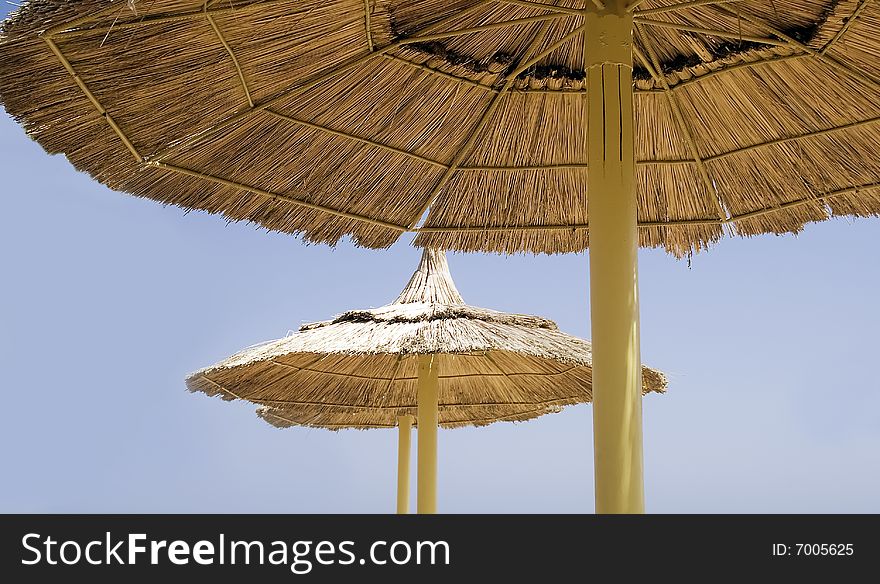 Large straw beach parasols by the Red Sea seaside