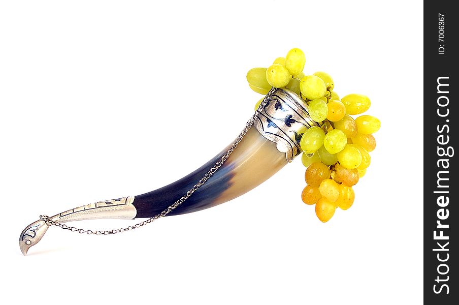 Drinking horn and grapes isolated on white background