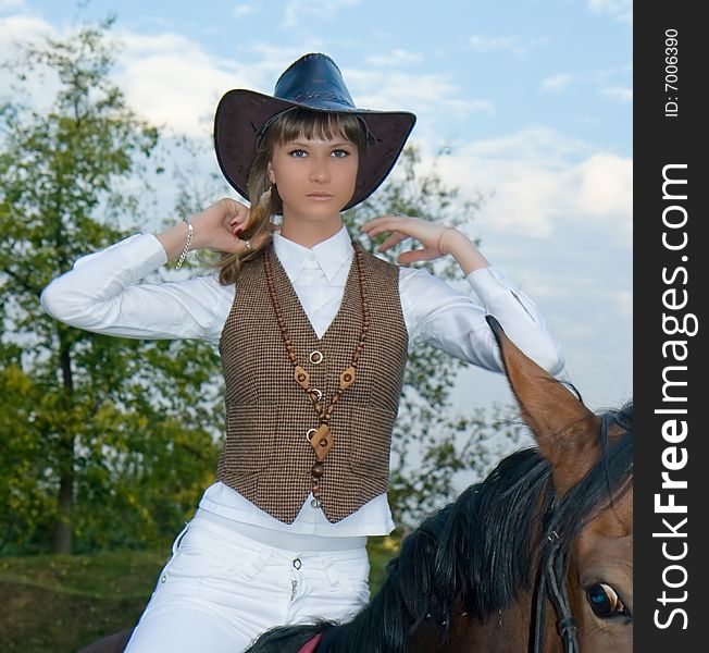 Pretty young woman riding  horse.