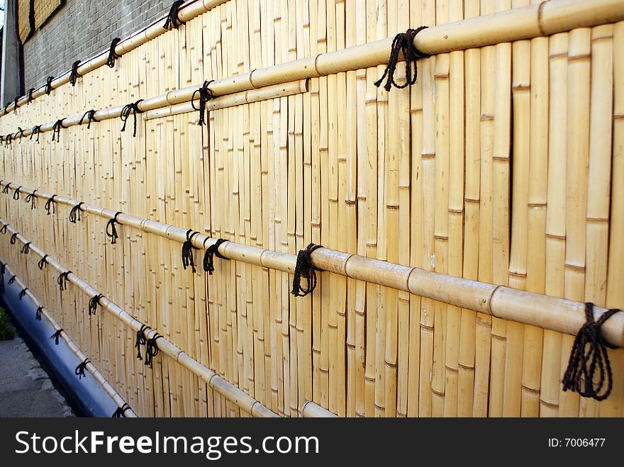 Typical Japanese bamboo fence with black wires. Typical Japanese bamboo fence with black wires
