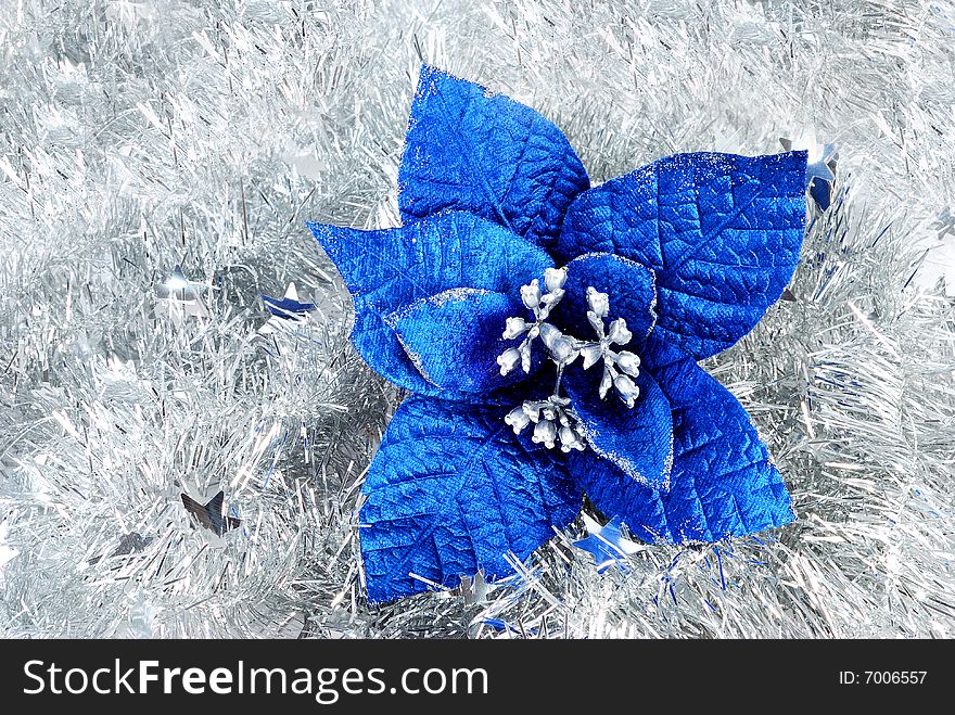 Christmas blue flower decorations on silver tinsel. Christmas blue flower decorations on silver tinsel