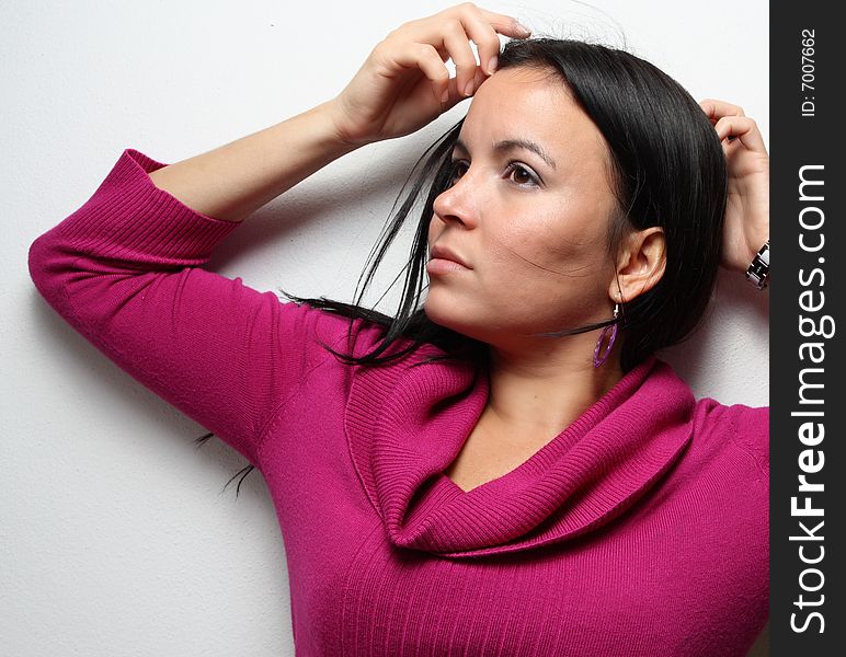 Young female posing on a white wall