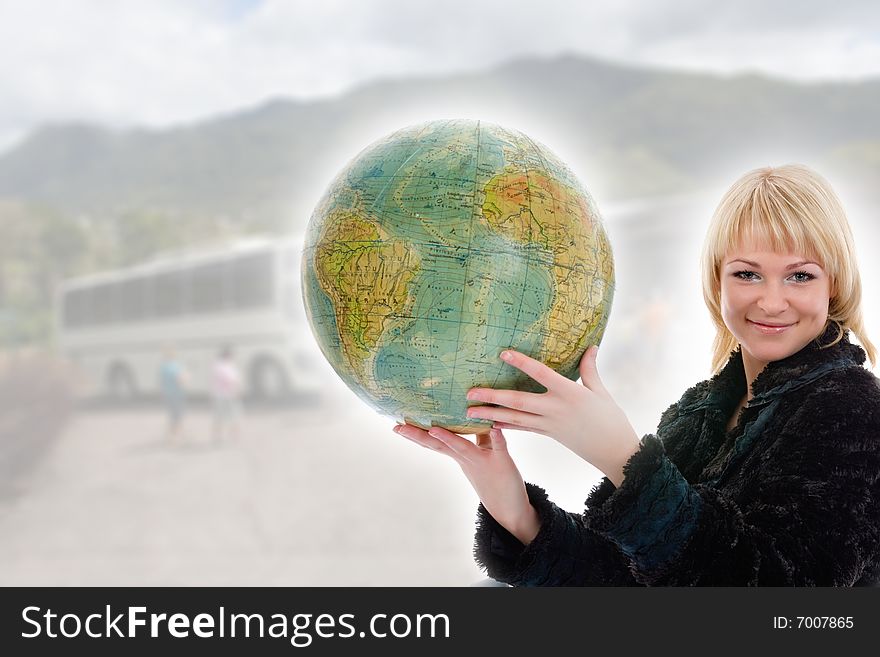 Beautiful blonde with valise and globe on background