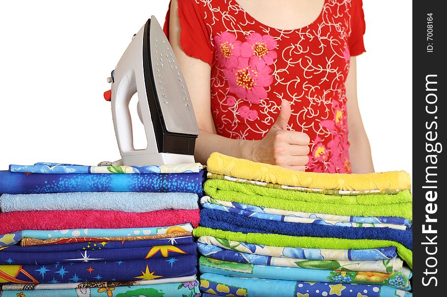 Household iron and greater pile of bed-clothes on a white background. Household iron and greater pile of bed-clothes on a white background.