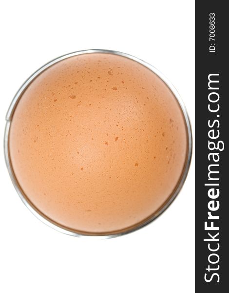 Brown egg in an eggcup on white background