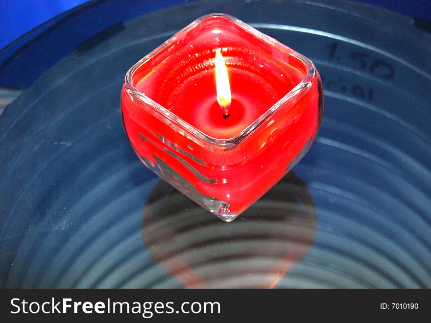 A candle with blue metalic background