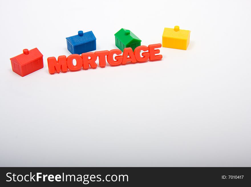 Toy houses surrounding the word mortgage, with copy space beneath. Toy houses surrounding the word mortgage, with copy space beneath