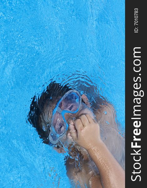 A young boy in pool with goggles on. A young boy in pool with goggles on