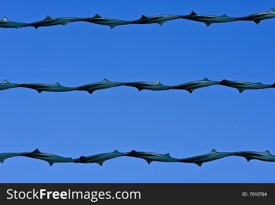 A modern barbed wire on a blue sky. A modern barbed wire on a blue sky