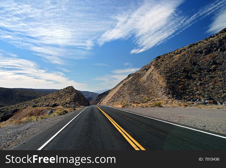 Barren desert road with clouds and sky. Barren desert road with clouds and sky