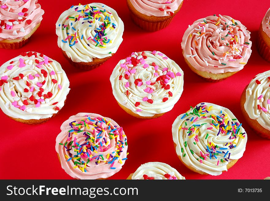 Pink and white frosted cupcakes with sprinkles. Pink and white frosted cupcakes with sprinkles