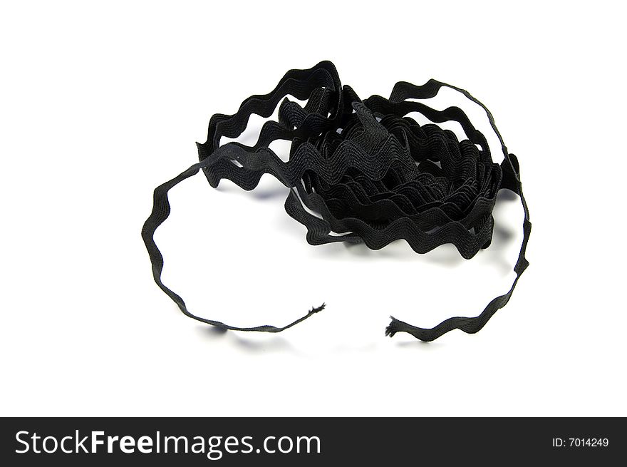 A photograph of black wavy ribbon against a white background. A photograph of black wavy ribbon against a white background