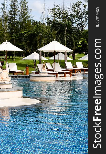 Deck chairs and umbrellas next to a swimming pool. Deck chairs and umbrellas next to a swimming pool.