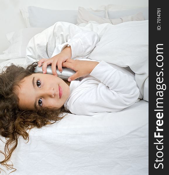 Little girl lying and talking on the phone. Little girl lying and talking on the phone