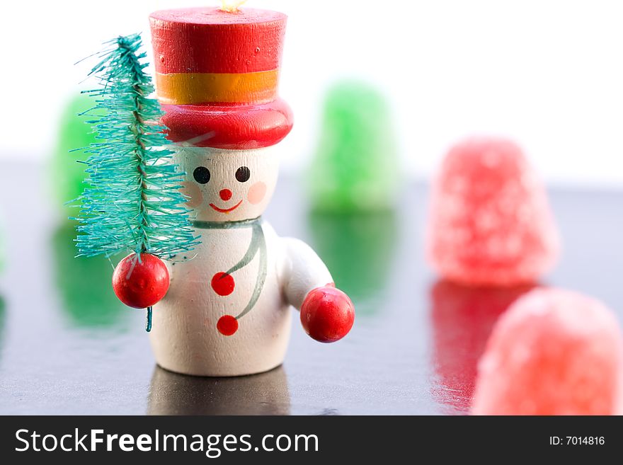 A Snowman carrying a tree on ice with a background of gumdrops. A Snowman carrying a tree on ice with a background of gumdrops.