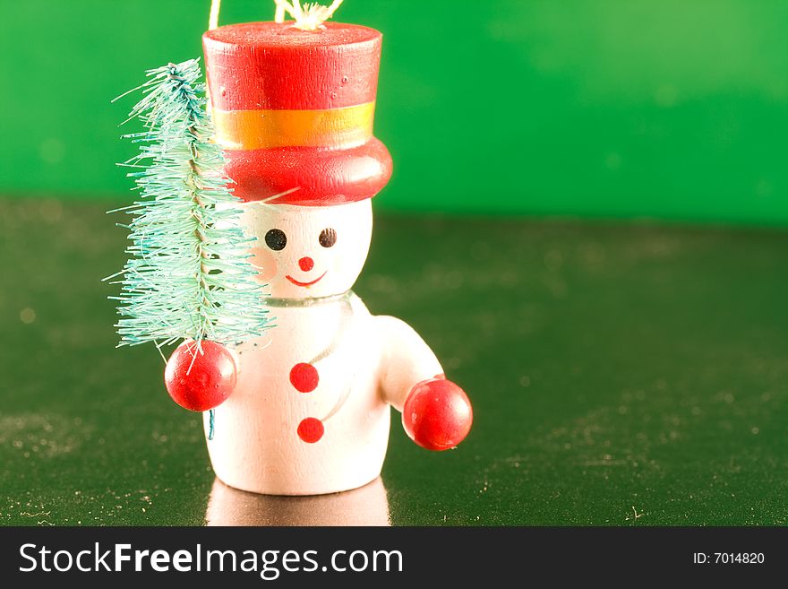 A Snowman carrying a tree on icey green background. A Snowman carrying a tree on icey green background.