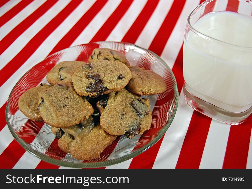 Plate of cookies with milk on festive stripes. Plate of cookies with milk on festive stripes.