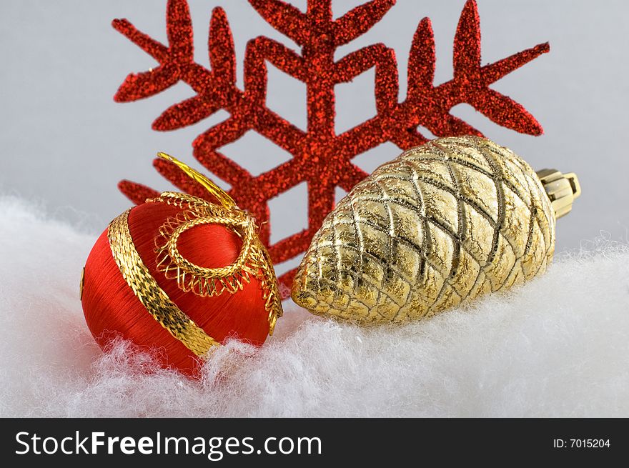 Red Christmas bauble with golden pine cone and red snowflake in the background. Red Christmas bauble with golden pine cone and red snowflake in the background