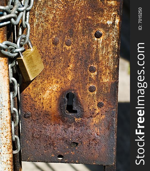 Rusted keyhole with padlock and chain