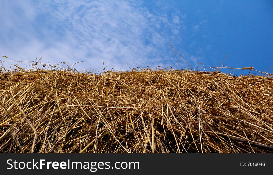 Straw haystack on blue sky with clouds. Straw haystack on blue sky with clouds