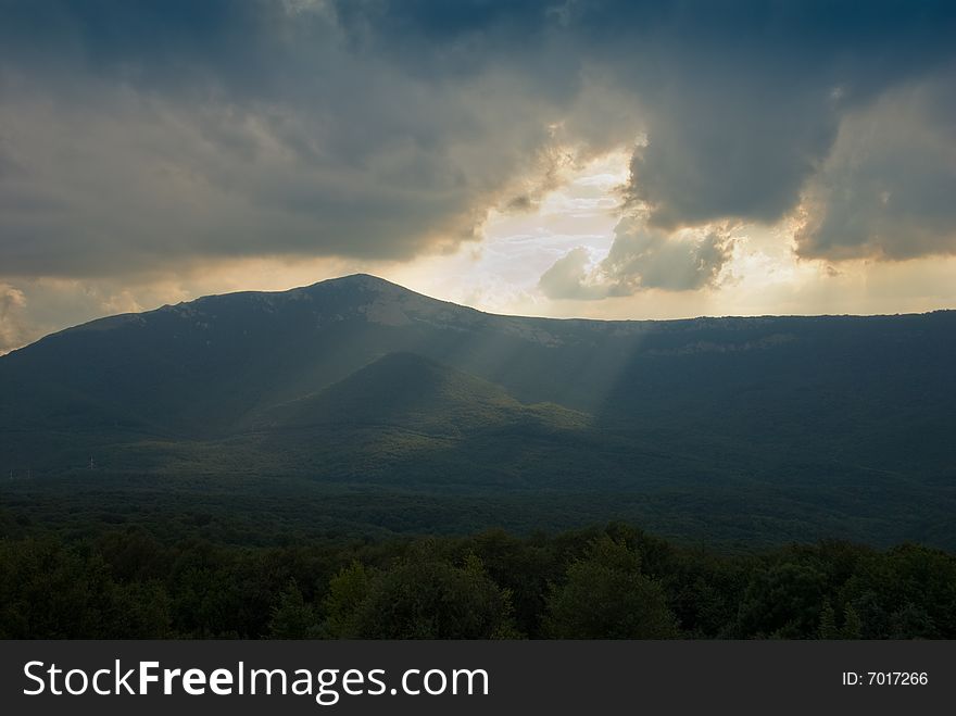 Sunbeams through the cloudy sky in mountains