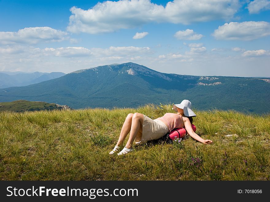 Happy all-in hiker relaxes on the grass in mountains. Happy all-in hiker relaxes on the grass in mountains
