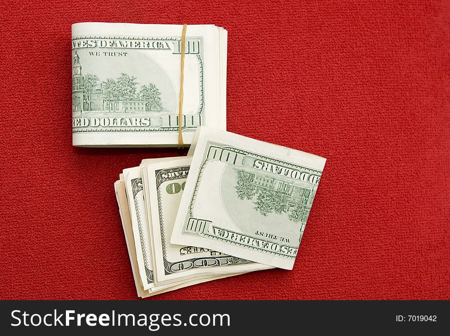 Stack of $100 bills on red background