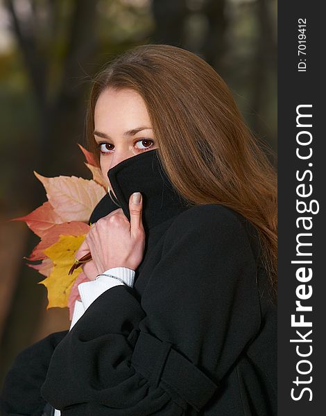 Young girl hides behind stand-up collar.