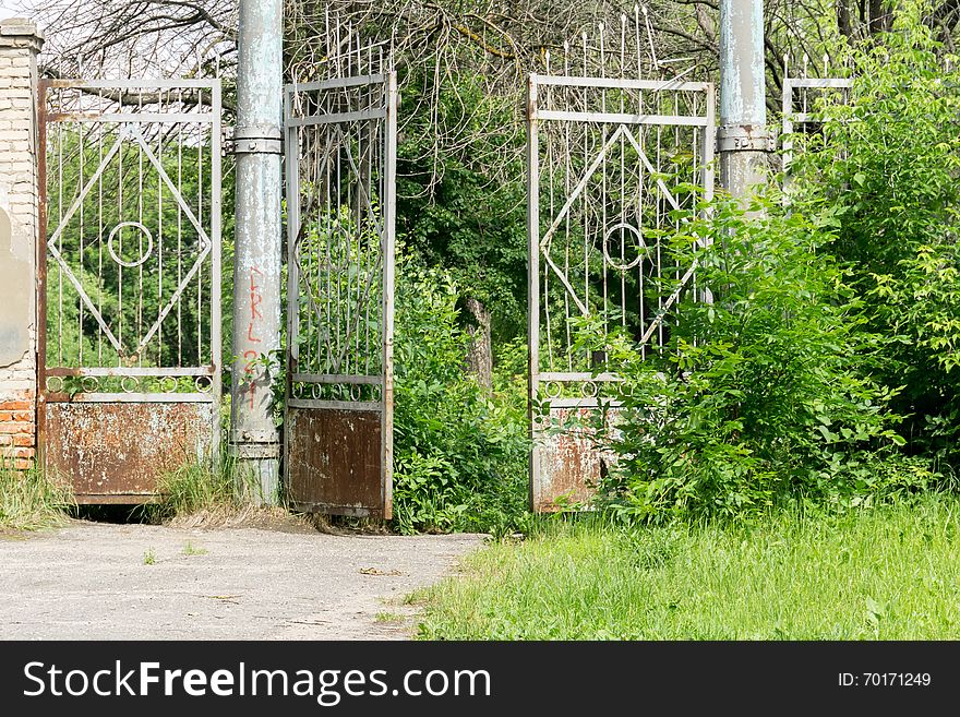 Abandoned rural stadium metal gate and green foliage. Abandoned rural stadium metal gate and green foliage.