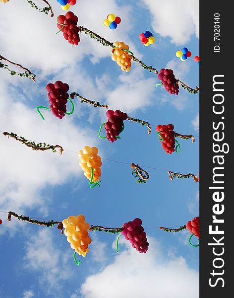 Balloons in the shape of grapes hanging on the cloud sky background (wine holiday). Balloons in the shape of grapes hanging on the cloud sky background (wine holiday)