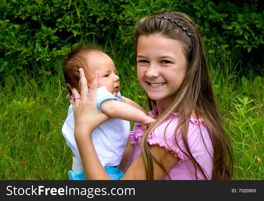 Happy little girl holding her baby brother. Happy little girl holding her baby brother